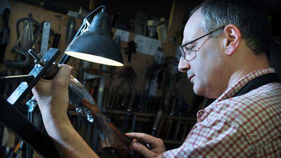 Jason Harris working on the stock of a gun
